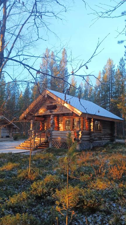 a log cabin in the woods with lights on at Norcota- Blockhaus mit Auroraskylight in Inari
