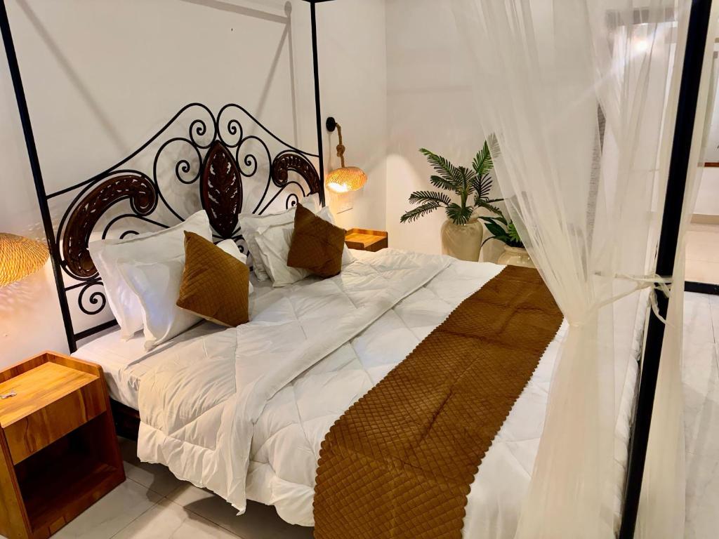 a bedroom with a bed with a black and white canopy at cali stays in Chapora