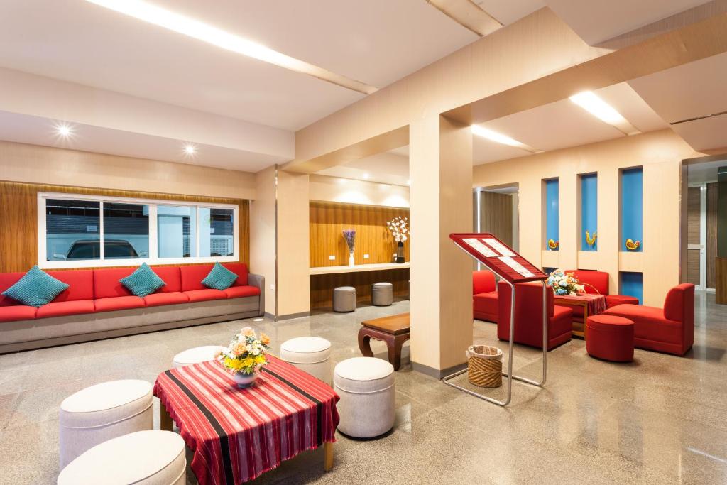 A colorful hotel lounge with red sofas, a striped coffee table and a reception counter.