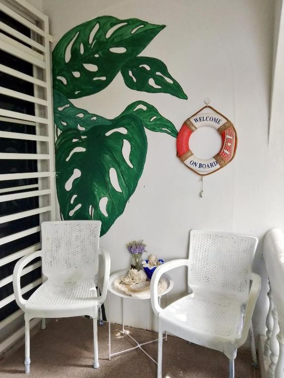 a room with two chairs and a sign on the wall at Aura Bluewave Beach House, Chenang in Pantai Cenang