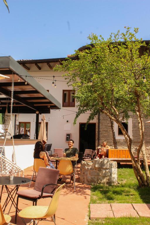a group of people sitting at a table in a yard at Shkodra Hostel & Day Tours in Shkodër