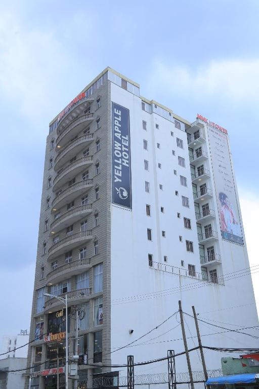 a tall building with a sign on the side of it at yellow apple hotel in Addis Ababa