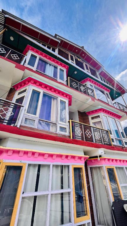 a building with white and pink windows on it at Dolma Homestay By Orko in Nachar