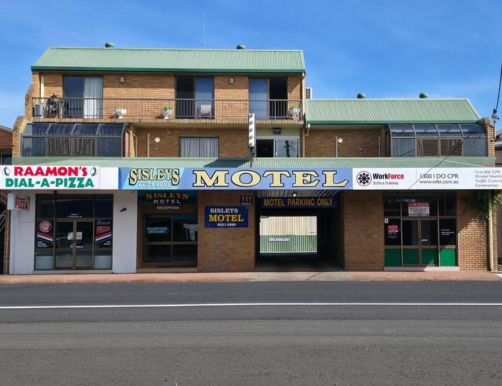 a brick building with a sign for a motel at Sisleys Motel in Lismore