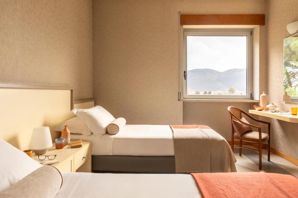 a hotel room with two beds and a window at Hotel Al Sant'Andrea in Sarzana