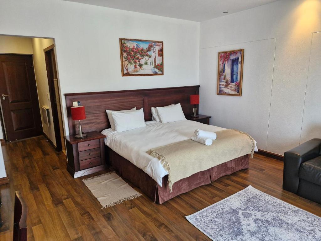a bedroom with a large bed and a couch at BergWood Inn in Great Brak River