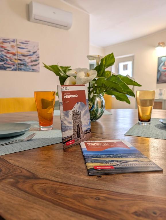 a table with a book and a vase of flowers at Borgo Mare in Piombino