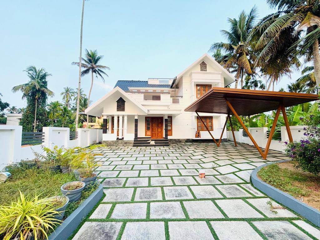 a house with a stone walkway in front of it at THE iVORY VILLA in Kottayam