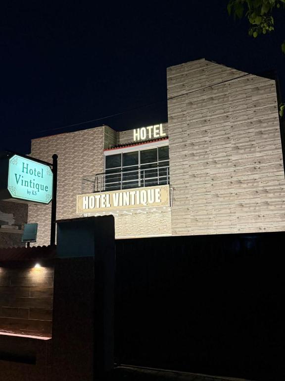 ein Hotelgebäude bei Nacht mit Schildern darauf in der Unterkunft Hotel Vintique in Lahore