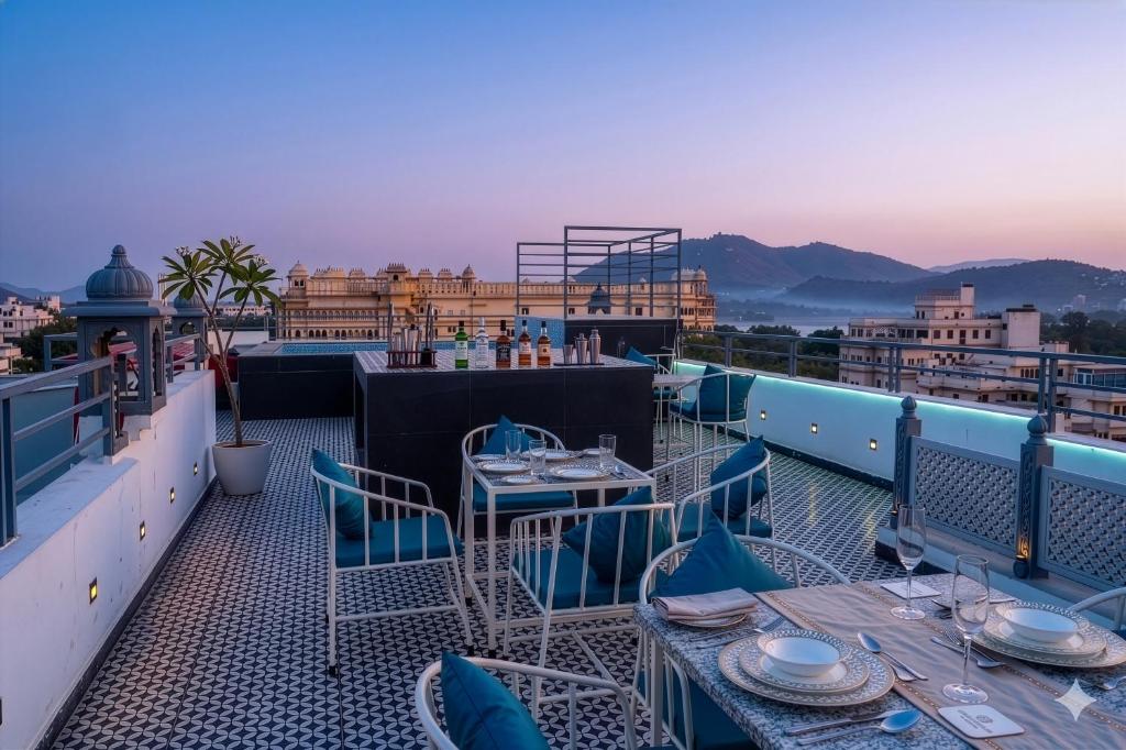 a patio with tables and chairs on a roof at UDAISA - The Luxury Art in Udaipur