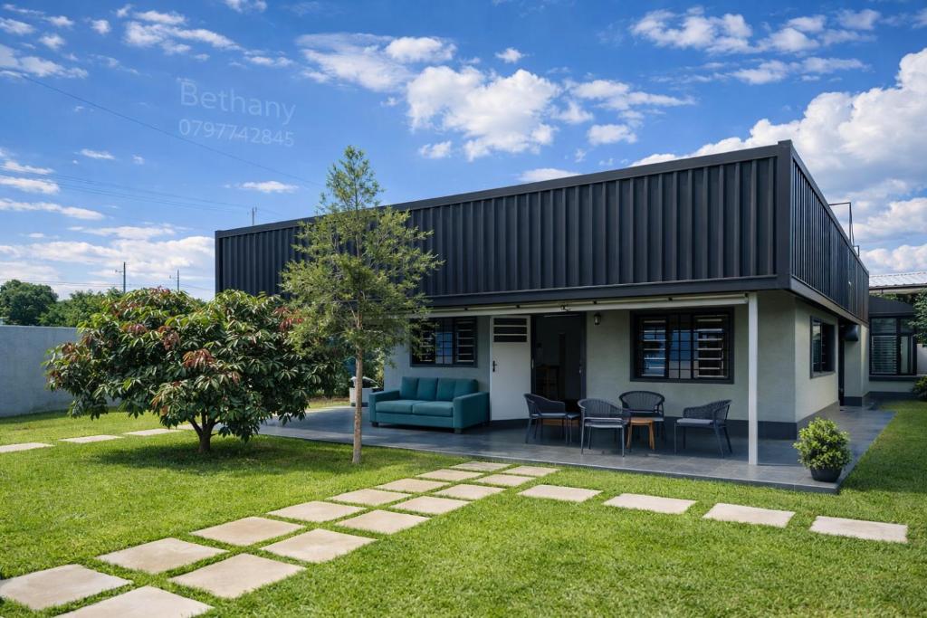 a house with a black roof and a yard at Kisii cottage in Kisii