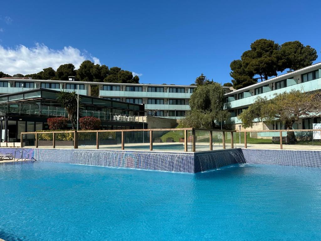a large swimming pool in front of a building at Aparthotel Comtat Sant Jordi in Platja d'Aro