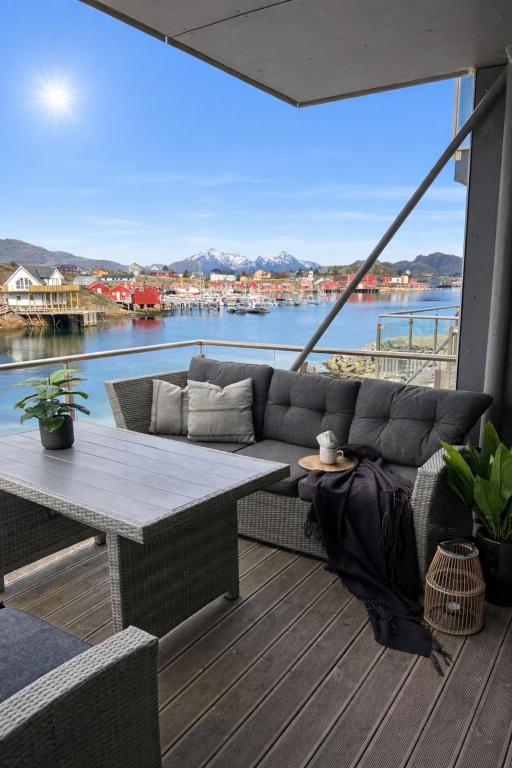 a living room with a couch and a table on a deck at Villa Lofoten balcony view in Ballstad