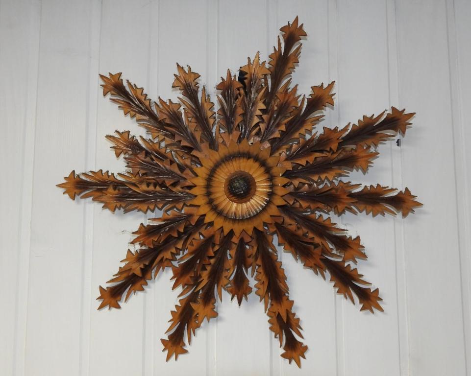 a wooden sunflower on a white wall at Pokoje pod Turbaczem in Ostrowsko