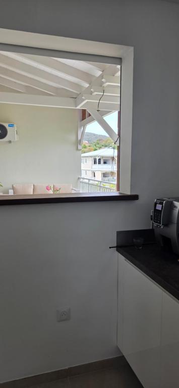 a kitchen with a counter top with a window at Anse a l ane in Les Trois-Îlets