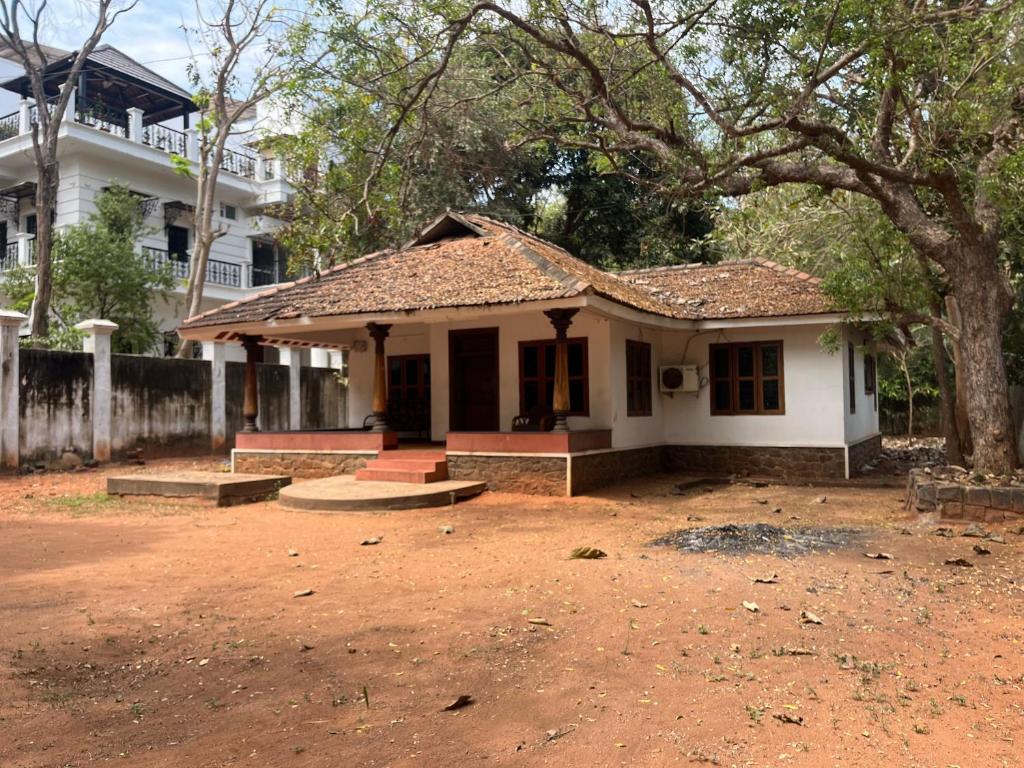 a small white house with a tree in front of it at Gravity Groups SSK - Near Sangamithra Jipmer in Puducherry Airpoert