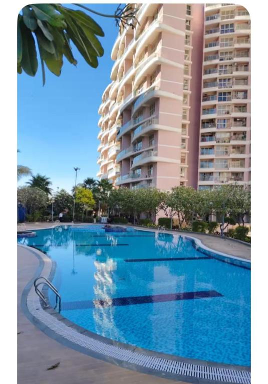a large swimming pool in front of a large building at The Aura stays in Indore