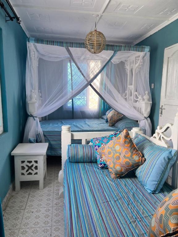 a bedroom with two beds and a window at Khangadelic Kilifi in Kilifi
