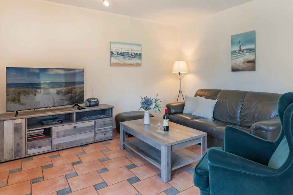a living room with a couch and a tv at Ferienwohnung Wassermann in Loddin