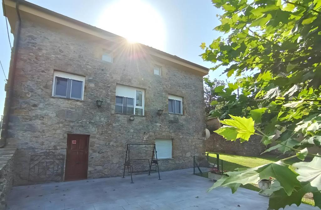 a large stone building with the sun shining on it at La Casona de Ilusión in Solórzano