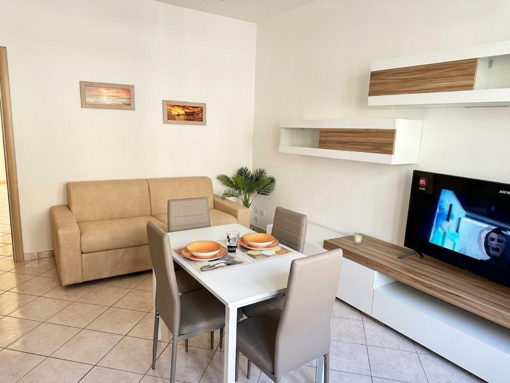 a dining room with a white table and a television at Fiorucci Apartments - Daniele's House Lago Di Bolsena in Marta