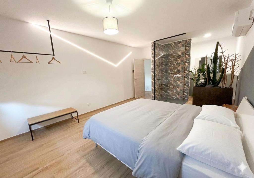 a bedroom with a large white bed and a bench at Li Piagge Guest House in Ascoli Piceno