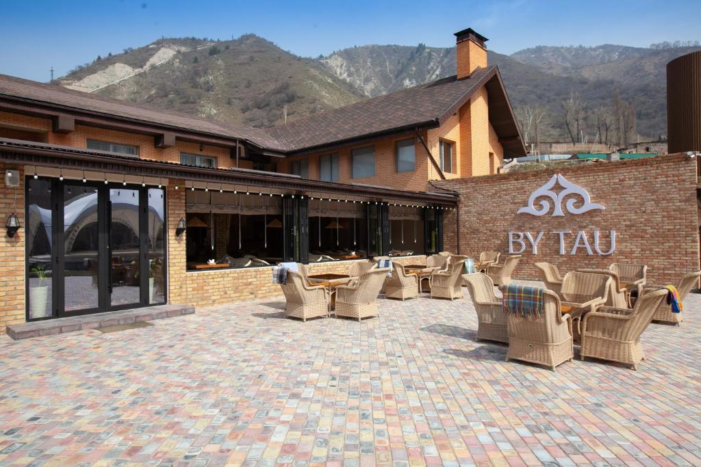 a group of chairs and tables in front of a building at By Tau in Almaty
