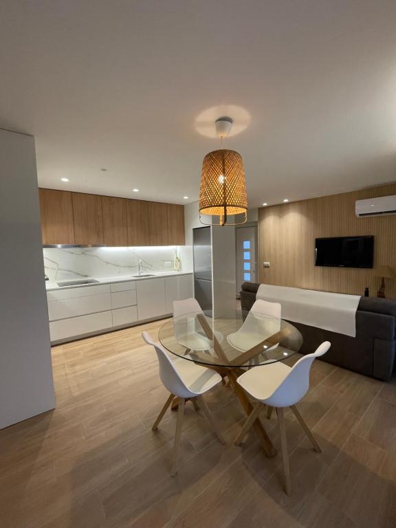 a living room with a glass table and chairs at Areias do Norte in Póvoa de Varzim