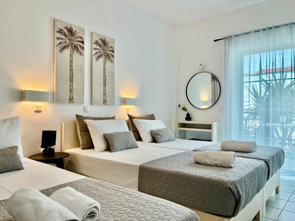 a hotel room with two beds and a mirror at Thalassa Garden Studios in Pefkochori