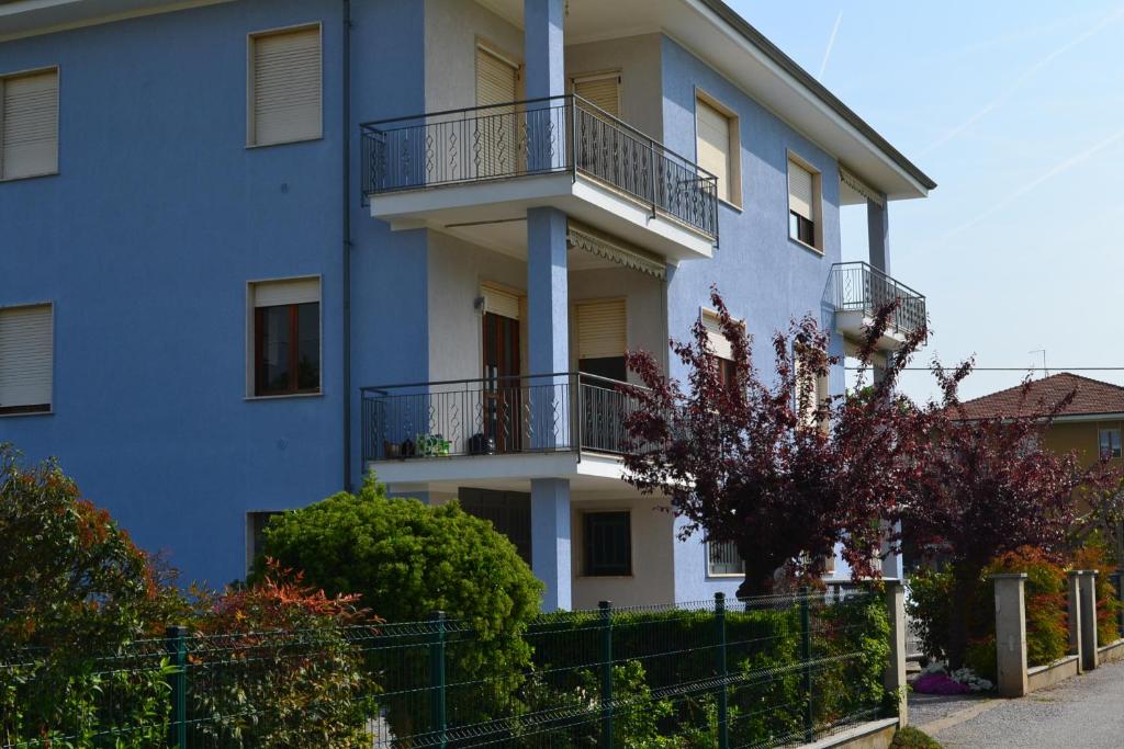 an apartment building with balconies and bushes at Alloggio per 4 persone con due camere da letto e cucina in Carrù
