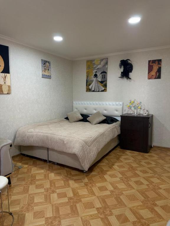 a bedroom with a large bed and pictures on the wall at sofia guest house in Chiatʼura