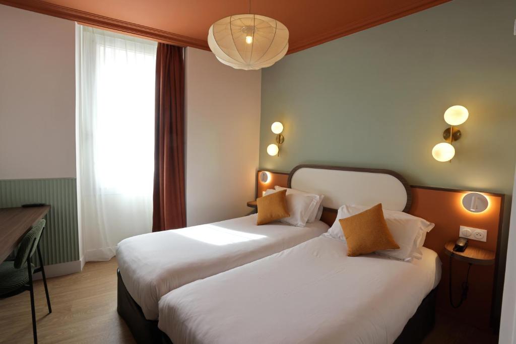 a hotel room with two beds and a window at Hotel Boréal Nice in Nice