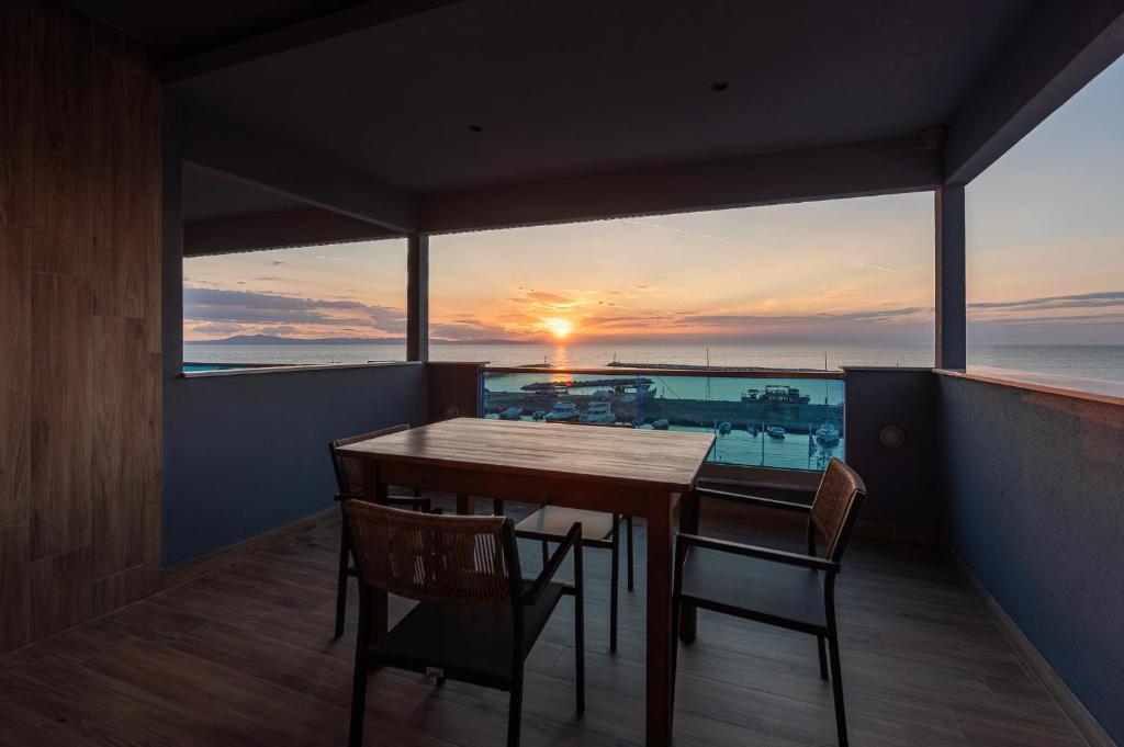 a table and chairs on a balcony with the sunset at Poseidon 5 in Paralia Katerinis