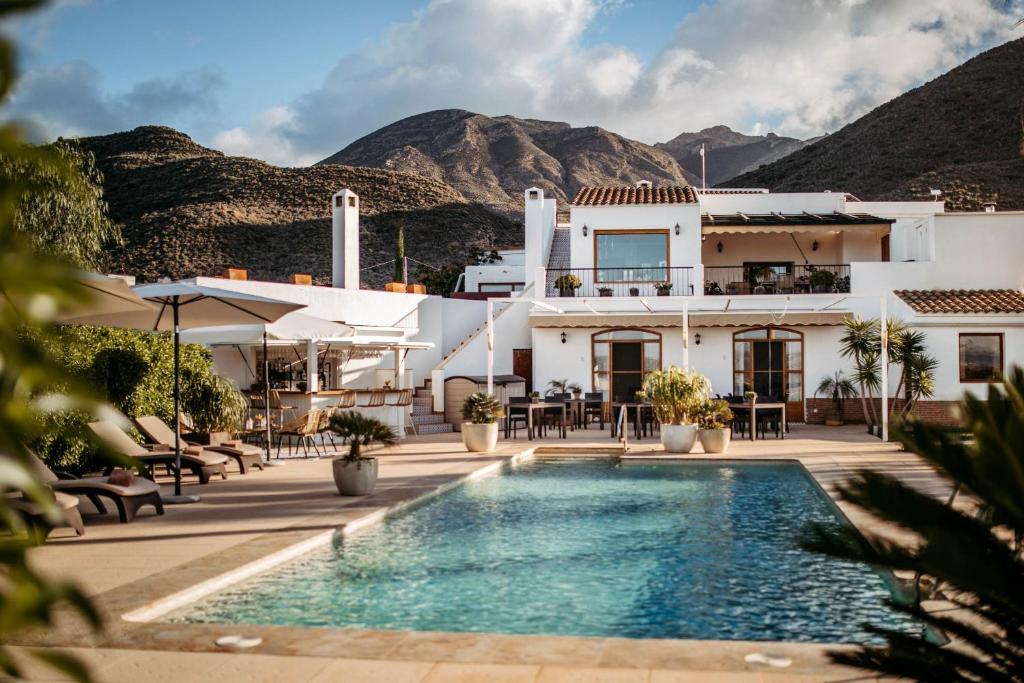 a villa with a swimming pool and mountains in the background at Boutique Hideaway Cortijo El Sarmiento - Adults Only in Mojácar