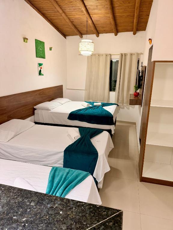 a bedroom with two beds and a counter at Pousada Portal da Mucugê in Porto Seguro