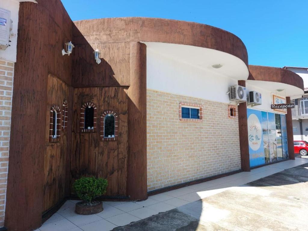 a building with a wooden door on a street at Pousada Luz do Sol in Penha