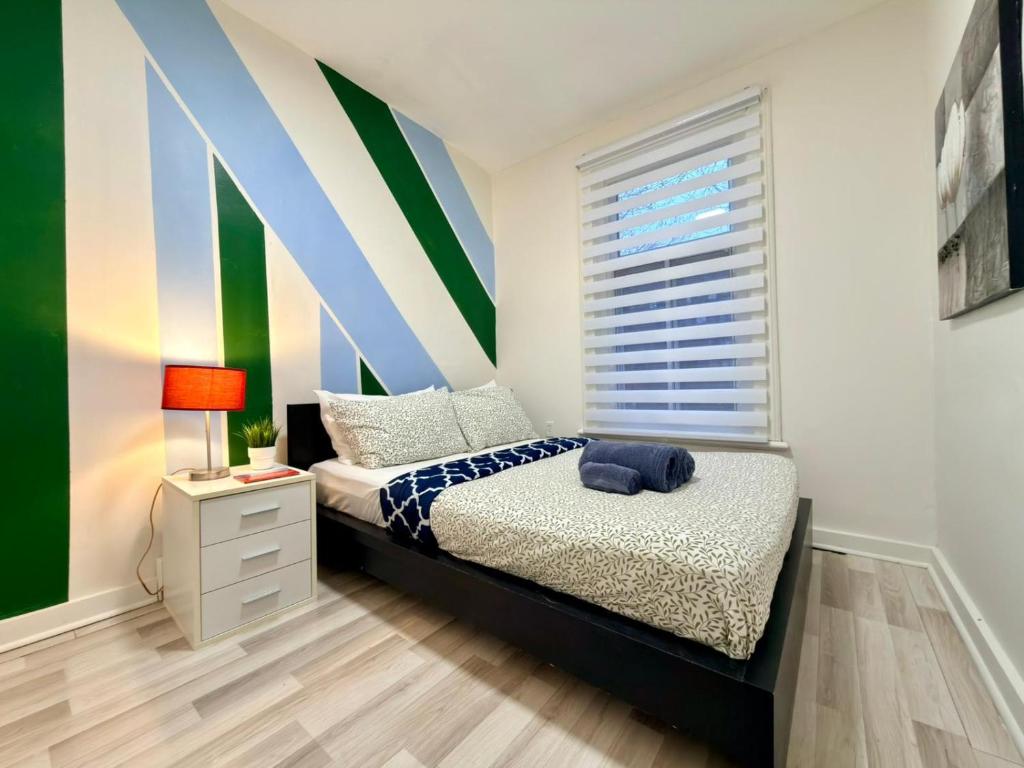 a bedroom with a bed and a striped wall at The Skyline Luxury Unit in Bélanger