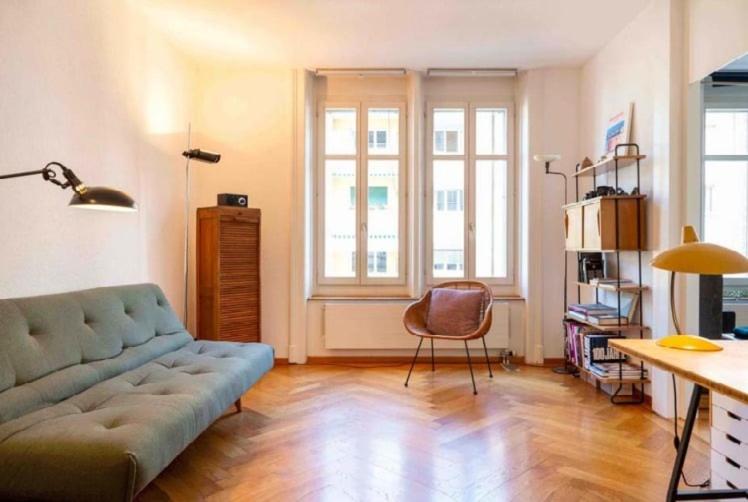 a living room with a blue couch and a chair at Flat 12-min walk to Bern station in Bern