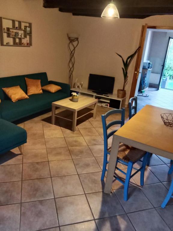 a living room with a green couch and a table at Maison au bord de l'Erdre in La Chapelle-sur-Erdre