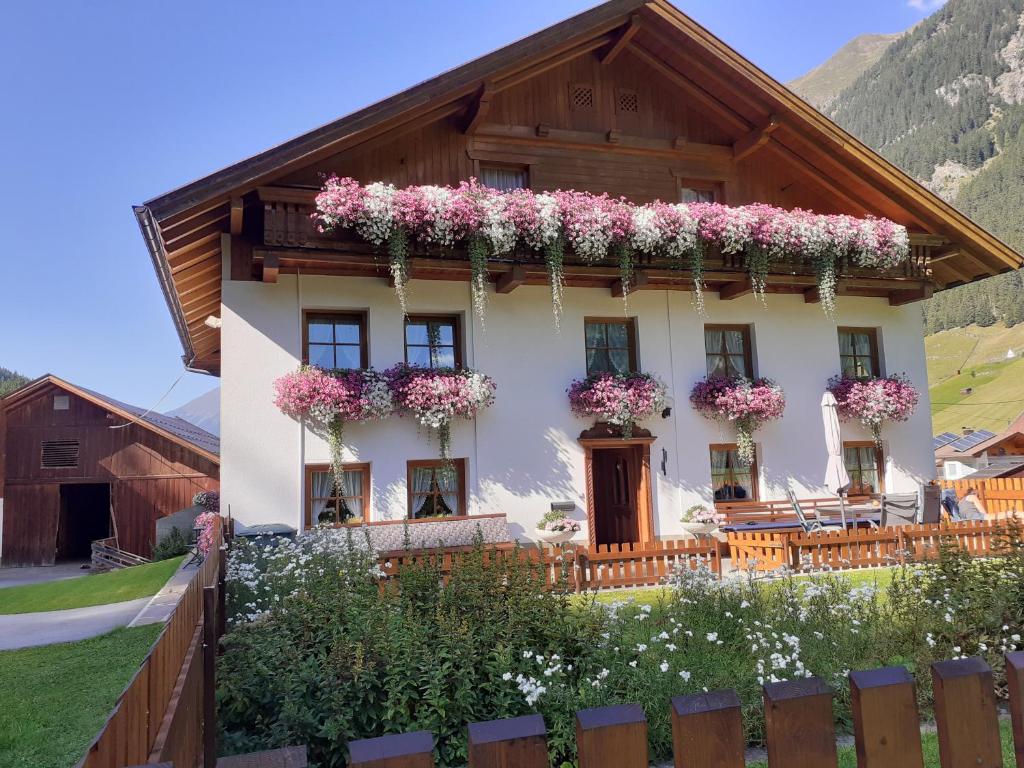 a house with flowers on the side of it at Haus Bödele in Sankt Leonhard im Pitztal