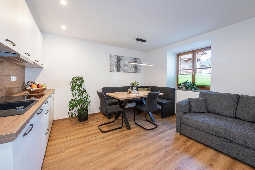 a kitchen and living room with a table and a couch at Wohnung Morgenduft Schnalserhof in Laces