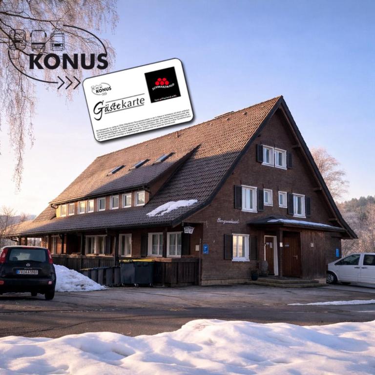 a large building with a sign on top of it at Pension Bergseeblick in Titisee-Neustadt