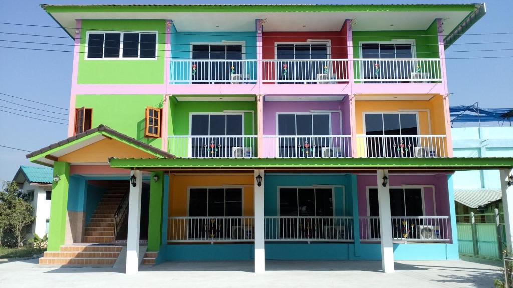 a brightly colored house with a balcony at Rueangsrisiri Guesthouse 2 in Sukhothai