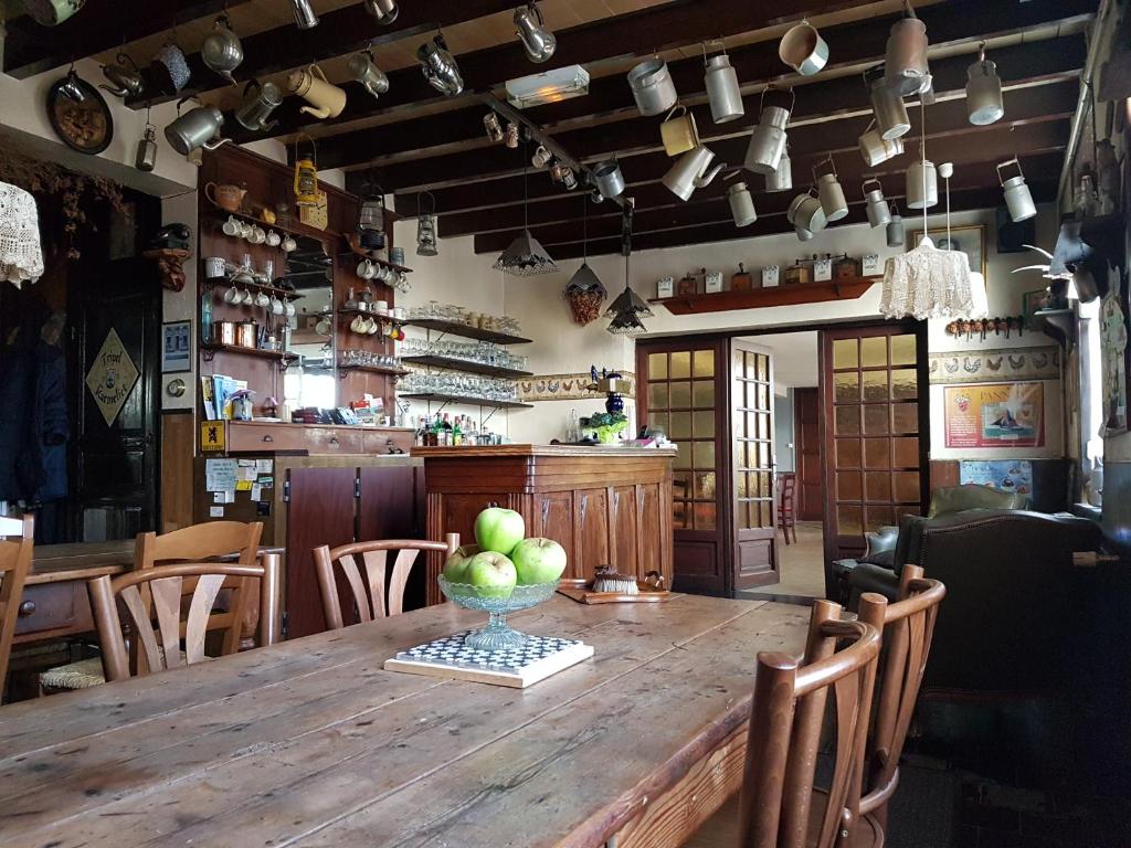 uma grande mesa de madeira com uma tigela de maçãs em Au Gallodrome Maison d'hôtes et Table d'hôtes en Estaminet privé em Drincham
