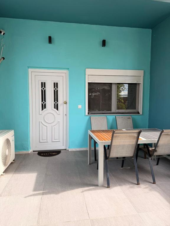 a dining room with blue walls and a table and chairs at M&L apartment Large in Perea