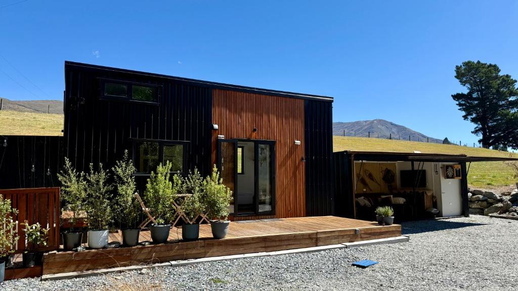 a black house with potted plants in front of it at Grace & Rose in Gibbston