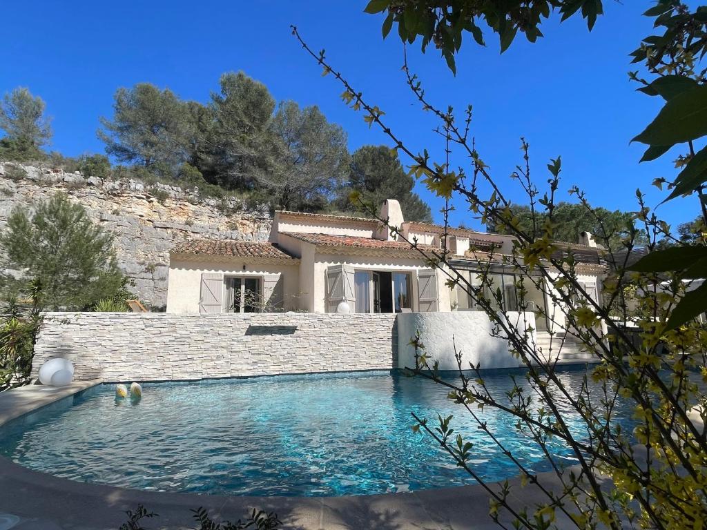 a villa with a swimming pool in front of a house at La villa des Carriers - maison avec piscine, 10 min mer in Roquefort-les-Pins