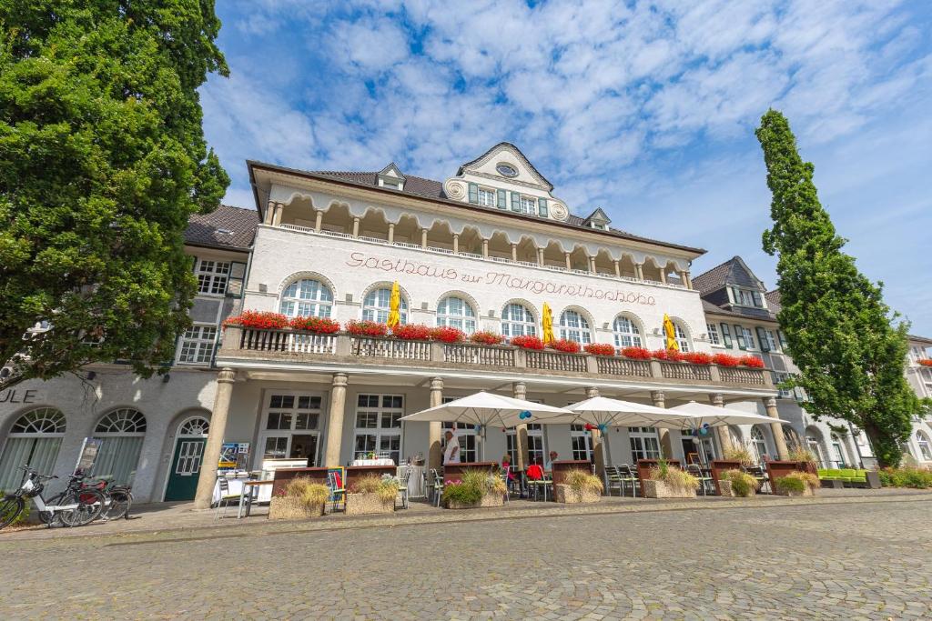 a large white building with umbrellas in front of it at Mintrops Stadt Hotel Margarethenhöhe in Essen
