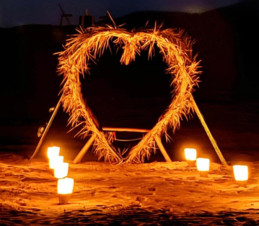 a heart made out of hay with candles in front at Merzouga Luxury Tents & Activities in Merzouga