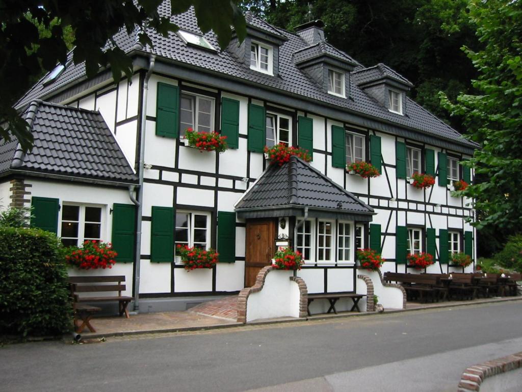 a white and green building with flowers on the windows at Wißkirchen Hotel & Restaurant in Odenthal